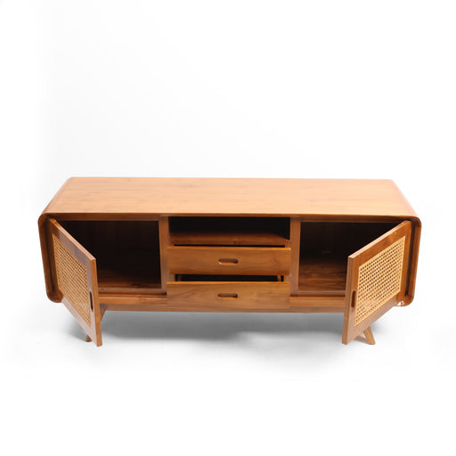 The Aurelia TV Console is a celebration of balanced geometry and organic warmth. Characterized by its signature "waterfall" frame, the unit features masterfully rounded corners that eliminate harsh lines, creating a sense of fluidity in your living space. The hand-woven rattan door panels provide a light, breathable texture that contrasts beautifully with the smooth, substantial timber frame.


Radius-Edge Craftsmanship: The softly curved silhouette offers a high-end, sculptural look that feels both modern and welcoming.

Woven Rattan Details: Artisan-inlaid rattan panels add a layer of vintage-inspired charm and natural ventilation for your media essentials.

Organized Storage Gallery: Features two central drawers for discreet storage and twin cupboards for larger items, keeping your entertainment area clutter-free.

Tapered Stance: Elevated on angled, splayed legs to provide a light, airy footprint and a nod to iconic mid-century design.
