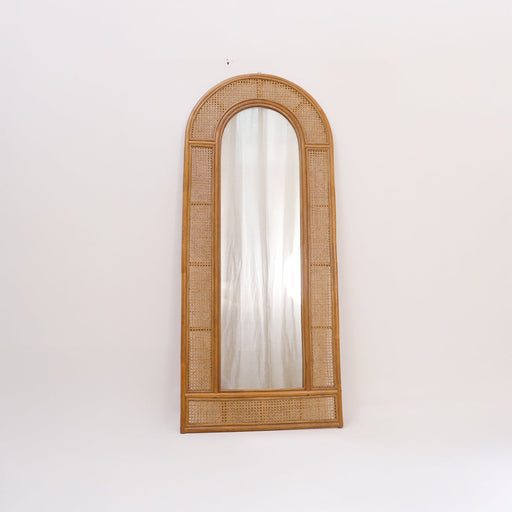 Elevate your home sanctuary with the Calen Arched Mirror. Embodying the Urban Oak philosophy where rustic materials meet refined design, this floor mirror moves far beyond a simple reflective surface—it is a piece of functional art.
Featuring an iconic arched silhouette and a frame hand-detailed with intricate cane webbing, it borders the premium glass with a delicate, airy texture that provides a sophisticated designer touch to your space. In a world of mass-produced synthetic mirrors, the Calen stands out with its genuine natural construction, grounding your home with a relaxed, warm, and sophisticated energy.
Why You'll Love It


Iconic Arched Silhouette: Features a sophisticated curved top that introduces a sense of architectural softness, elegance, and visual height to your walls, serving as a stunning focal point.

Artisan Cane &amp; Rattan Weaving: Meticulously handcrafted using a combination of premium natural rattan and tightly woven cane webbing, injecting rich organic texture and a warm bohemian charm into your curated interior.

Grand Full-Length Dimensions: Standing an impressive 180 cm tall and 75 cm wide, this mirror provides a flawless head-to-toe view—making it the ultimate addition to a dressing room, bedroom walk-in, or bedroom.

Lightweight Yet Durable Build: Our artisans focus on creating a structurally stable yet gracefully lightweight frame that showcases the unique, honest character of renewable, eco-friendly materials.

Product Specifications



Attribute
Details




Type
Full-Length Arched Floor Leaner or Wall-Mounted Mirror


Material
100% Natural Rattan, Authentic Cane Webbing &amp; Premium Glass


Style
Bohemian / Coastal / Scandinavian / Modern Rustic


Overall Dimensions
180 cm (Height) × 75 cm (Width) × 3 cm (Thickness)


Usage
Ideal for Bedrooms, Dressing Rooms, and Main Living Spaces


