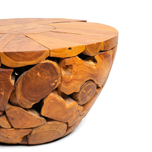 Introduce a dramatic element of natural history and high-end curation into your living area with the spectacular Cotswold Log Mosaic Coffee Table. Embodying the core Urban Oak design ethos—where sculptural contemporary forms beautifully intertwine with raw, unyielding materials—this handcrafted solid teak centerpiece is a true triumph of modern primitive styling.
By combining a smooth, functional sunburst top deck with a complex, clustered mosaic bowl base, it brings immediate texture, visual weight, and designer distinction to your home layout. In an everyday furniture marketplace saturated with mass-produced, lightweight hollow plastic tables and artificial synthetic laminates, the Cotswold commands immediate respect as a genuine solid wood legacy piece.
Why You'll Love It


Premium Solid Teak Wood Build: Meticulously handcrafted from 100% genuine solid Teak wood chunks. Celebrated globally for its unparalleled structural density, natural oils, and deep resilience, this heavy-duty table provides an ultra-stable, non-wobbly base built to last generations.


Artisan Log Mosaic Structure: Features a breathtaking mosaic matrix body formed by hand-clustering raw teak branches and log slices. The pieces are carefully selected and interlocked like a puzzle to form a beautiful sculptural bowl shape that serves as an immediate focal point in your room.


Exquisite Radial Sunburst Top: The flat tabletop surface showcases a striking, hand-pieced radial sunburst configuration. The rich walnut-toned wood sections fan out from a central core, displaying cross-cut growth rings, sweeping grain lines, and raw wood knots that highlight the natural lifecycle of the timber.


Expansive Statement Footprint: Spanning an impressive 80 cm in diameter and standing at a comfortable 45 cm coffee table height, its generous proportions make it the perfect anchor for large sectional sofa layouts, light-filled sunrooms, or high-end lounge spaces.


Product Specifications



Attribute
Details




Material
100% Genuine Premium Sustainable Solid Teak Wood Chunks


Shape
Round Architectural Bowl Base with Flat Circular Top


Style
Modern Primitive / Log Mosaic / Organic Modern / Coastal Luxury


Finish
Hand-Polished Natural Teak Satin Luster with Deep Walnut Undertones


Overall Dimensions
80 cm (Diameter) × 45 cm (Height)


Usage
Ideal for Living Rooms, Reception Lounges, Creative Studios, and Covered Patios / Sunrooms


