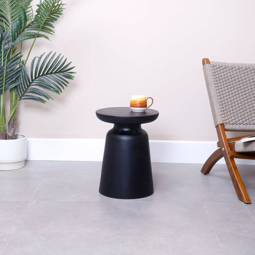 Introduce a warm element of high-end organic design and fluid geometry into your living space with the spectacular Kamila Side Table. Embodying the core Urban Oak philosophy—where unyielding, natural elements seamlessly merge with refined contemporary architecture—this hand-carved pedestal table is a true triumph of artisan craftsmanship.
Its sculptural goblet silhouette grounds small and large rooms alike with immediate visual weight, natural warmth, and high-end designer contrast. In an everyday furniture market saturated with mass-produced, lightweight hollow core plastic and compressed veneer composites, the Kamila commands respect as a genuine solid wood legacy piece, hand-shaped to perfection from a single substantial timber block.
Why You'll Love It


Premium Monkey Pod Timber: Handcrafted entirely from 100% authentic, sustainable Monkey Pod solid wood (Suar). This coveted tropical hardwood is prized by designers for its signature wild, interlocking grain patterns, high structural density, and rich multi-toned color depth.


Sculptural Goblet Silhouette: Featuring a striking, goblet-inspired architectural pedestal silhouette. Lacking sharp corners, its smooth, rounded contours bring fluid organic movement into your space, breaking up the straight lines of traditional furniture to act as a functional piece of art.


Rich Textured Finish: Coated in a luxurious, warm natural stain that beautifully amplifies the dramatic dark streaks and golden undertones natural to Monkey Pod wood. The entire frame is hand-polished to a premium, silky-smooth finish that feels incredible to the touch.


Compact Multipurpose Profile: Measuring 34 cm in diameter and standing 45 cm tall, this space-conscious accent table aligns perfectly with modern low-profile sofa layouts and lounge armrests. Use it as a stylish side drink table, a unique bedroom nightstand, or a sturdy extra sitting stool.


Product Specifications



Attribute
Details




Material
100% Premium Genuine Sustainable Solid Monkey Pod Wood


Shape
Round Pedestal Goblet Silhouette


Style
Goblet / Sculptural Art / Japandi / Organic Modern Luxury


Finish
Hand-Polished Natural Finish / Black &amp; Walnut



34 cm (Diameter) × 45 cm (Height)


Usage
Ideal as a Living Room Side Table, End Table, Bedroom Nightstand, or Unique Accent Stool



